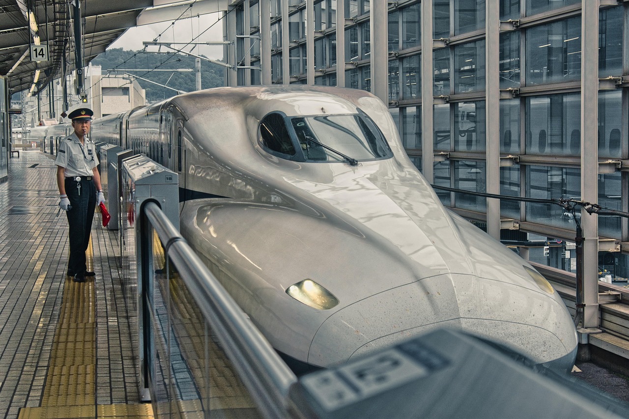 朝日が差し込む駅のホームで電車を待つ通勤の様子