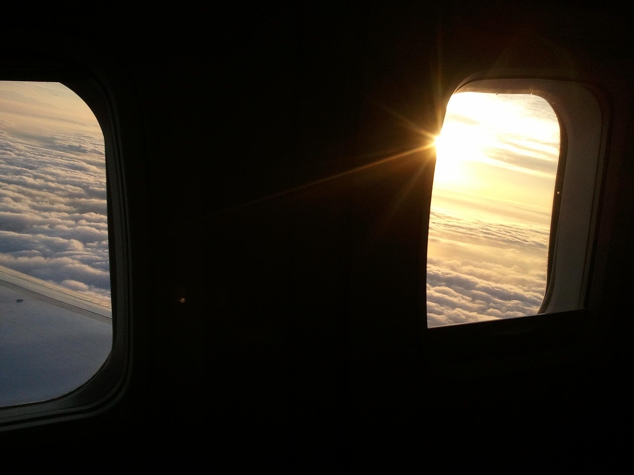 飛行機の窓から見える海と雲、海外赴任や出国をイメージした写真