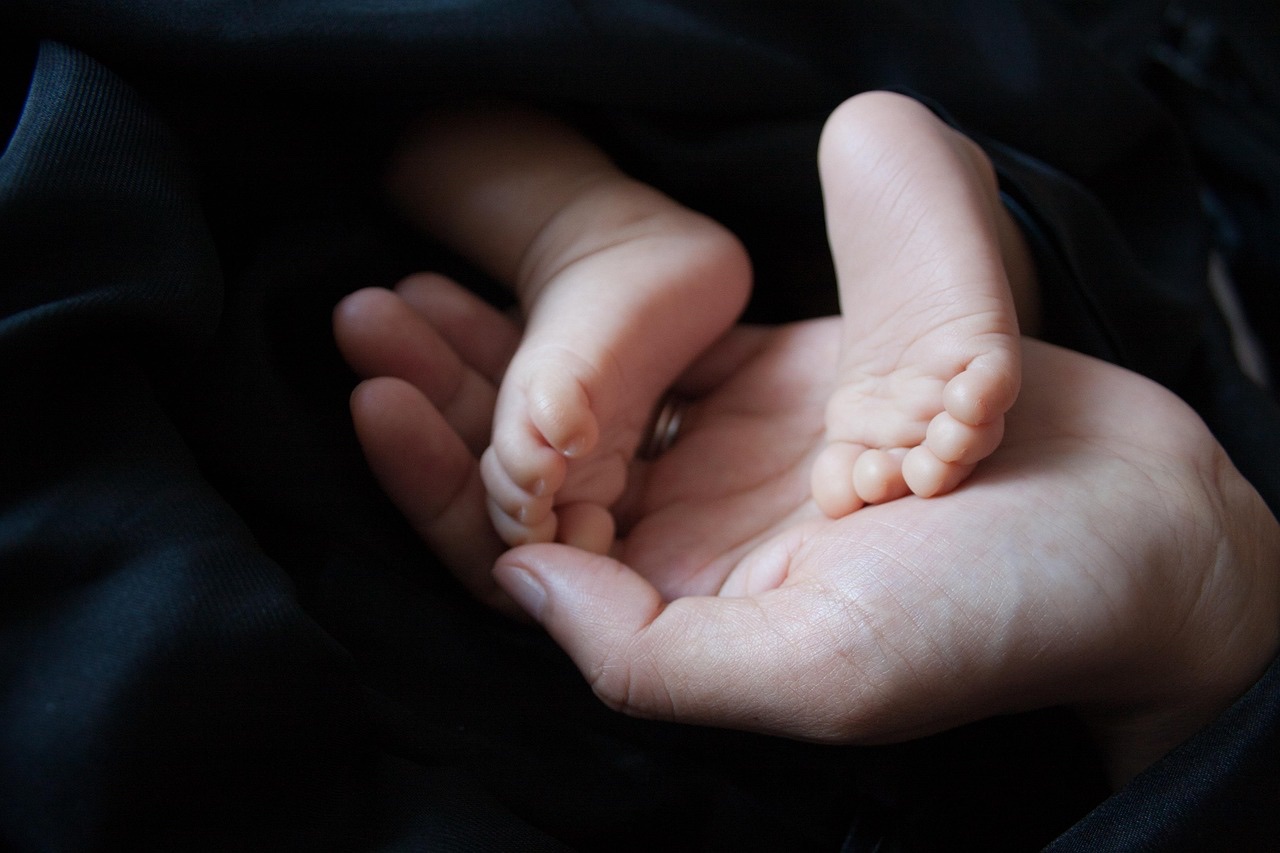 草の上に立つ赤ちゃんの足元、デジタル化が支える子育ての未来